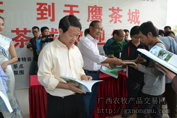 张明沛主任委员和肖志刚副市长给参展客商赠送书刊